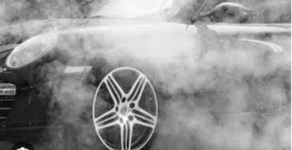 Förarens händer på ratten medan bilen luktar bränt – illustration av orsaker till varför bilen luktar bränt.